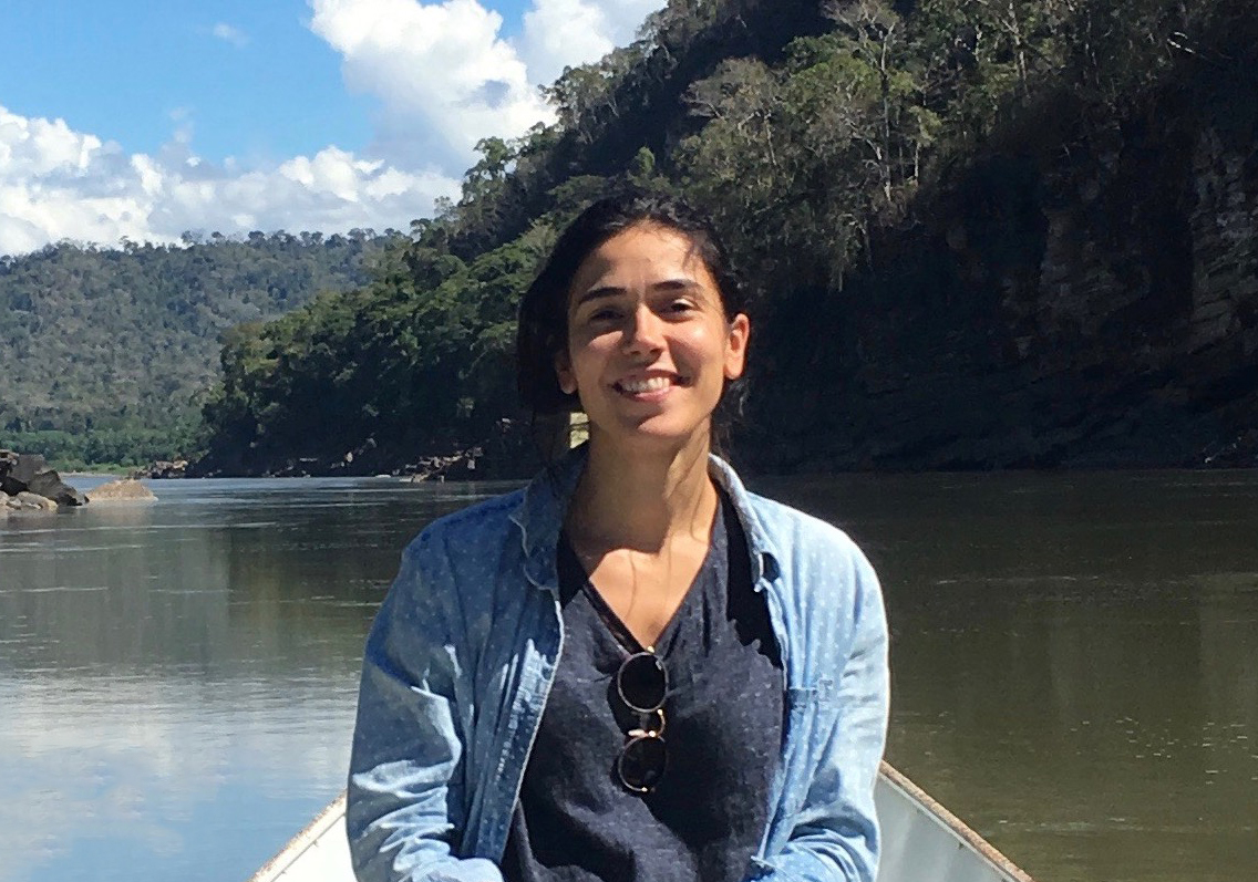Laura Fernández Cascán sitting on a boat, floating on a river in Peru
